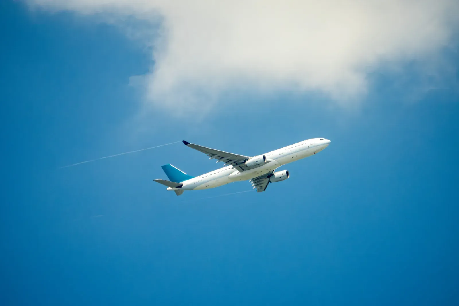 An airliner banking against a bright blue sky.